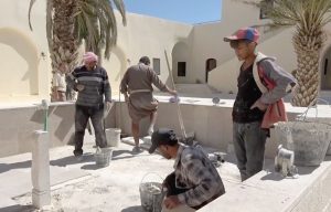 Российские тележурналисты, побывавшие на днях в этой провинции, рассказывают, что власти продолжают усилия по восстановлению инфраструктуры города Тадмор, расположенного в оазисе посреди Сирийской пустыни в 215 километрах к северо-востоку от Дамаска. Руины древней Пальмиры, Всемирного наследия ЮНЕСКО, находятся всего на расстоянии около 500 метров к юго-западу от современного центра города. Хасан укладывает плитку из того же материала, из которого его предки строили этот гостевой дом в Пальмире. Осталось ещё немно- го – и здание, разрушенное бомбёжками, снова сможет принимать своих постояльцев. Рабочие усердно трудятся каждый день, приближая трогательный момент открытия. «Нам осталось отремонтировать пару помещений и сделать небольшое кафе на террасе, на втором этаже. Всё остальное готово», – говорит Махмуд Асад. Здесь уже практически всё восстановлено, как и было прежде. В этом гостевом доме всего 12 номеров. До войны он пользовался популярностью у постояльцев из других стран. Пока идёт финишная отделка, гостевой дом уже принял первых посетителей. Это группа учёных из Российской академии наук. Владелец дома говорит, что будто заново родился. «Эта стройка вернула мне и вообще горожанам надежду на то, что Тадмор скоро станет прежним. Я уже и не помню, когда работал с таким хорошим настроением, как сейчас, на этом объекте. Мы всё сделаем для того, что бы вернуться к нашему образу жизни», – пообещал каменщик Хасан Хайдар. «Невеста пустыни» – Пальмира спустя три года после освобождения от боевиков «Исламского государства» (террористическая организация, запрещённая в РФ) снова начинает приобретать свой прежний облик. Пока одни готовят дома и улицы к приезду туристов, другие готовятся их встречать и развлекать. Можно сказать, что культурная жизнь уже вернулась в Пальмиру. В её древних амфитеатрах, как и раньше, проводят спектакли и дают концерты. Знаменитая на весь мир акустика этих античных сооружений всё такая же, как и тысячу лет назад. «Здесь всегда проводились лучшие концерты, мероприятия международного уровня. Мой оркестр приехал сюда впервые за все последние годы, и это, конечно, невероятное ощущение. Пальмира для меня и многих других музыкантов – источник вдохновения, она нам очень нужна», – заверил начальник оркестра Хасан Аль-Абад. Послушать эти концерты раньше приезжали люди со всего мира. Как только гостиницы будут достроены, в некогда прекраснейшем городе Сирийской пустыни снова ждут наплыва туристов. Поэтому огромное значение имеет и восстановление инфраструктуры. Городская больница уже работает практически в полноценном режиме. В ней функционируют диагностический кабинет, рентген, лаборатория анализов. Обновлена операционная, в родильном отделении стоит новейшее оборудование, а в реанимации дефибрилляторы и аппарат ИВЛ. Но пока остаётся проблема с персоналом. «До войны тут было 14 врачей и 325 младших медиков, а сейчас из врачей только я один и 150 младших медиков. Большинство уехали, кто-то ушёл на пенсию по старости, кто-то погиб», – признался главврач больницы в Пальмире Валид Аули. Конечно, жители пока надеются на внутренних туристов из Дамаска, Хомса, Латакии и других значимых городов, но в скором времени готовы будут принять и соседей из Иордании, Ливана и остальных арабских стран. В городе уже открыты несколько СТО для ремонта машин. Конечно, пока Пальмира не совсем может предстать перед гостями в своей величественной красоте. Послевоенные пейзажи здесь ещё видно повсеместно, но жители рассчитывают со временем всё восстановить. А пока главное – разместить туристов и обеспечить доступ в Старый город. Наша справка. В настоящее время в 345 населённых пунктах провинций Алеппо, Дамаск, Дейр-эз-Зор, Деръа, Латакия, Ракка, Хама, Хомс, Эль-Кунейтра и Эс-Сувейда ведутся работы по восстановлению и ремонту 2673 жилых домов, 225 школ, 178 дошкольных и 243 медицинских учреждений, 211 хлебопекарен, 203 электроподстанций, 283 водонасосных станций и 89 культовых сооружений. * * * Российский Центр по примирению враждующих сторон и контролю за перемещением беженцев в САР продолжает работу, направленную на невоенное разрешение конфликта и оказание всесторонней помощи сирийским гражданам в восстановлении мирной жизни. На днях представителями ЦПВС была проведена гуманитарная акция в населённом пункте Тасиль провинции Дамаск, в ходе которой населению выдано 500 продовольственных наборов общим весом 4,1 тонны. Всего с начала процесса урегулирования российским ЦПВС проведено 3027 гуманитарных акций. Сирийским гражданам доставлено и распределено 5298,86 тонны продовольствия, бутилированной воды и предметов первой необходимости. Продолжается выполнение положений российско-турецкого меморандума о взаимопонимании», принятого 22 октября 2019 года. На минувшей неделе состоялось очередное совместное российско-турецкое патрулирование в провинции Хасеке от пункта пропуска «Шейрек» до Киддла и обратно. Как сообщил на брифинге в пятницу заместитель руководителя российского ЦПВС контр-адмирал Вадим Кулить, на участке трассы М4 между населёнными пунктами Айн-Иса (провинция Ракка) и Телль-Тамер (провинция Хасеке) российской военной полицией за сутки обеспечено безопасное перемещение 863 человек и 391 автомобиля. В юго-западной провинции проводятся мероприятия по стабилизации обстановки. При посредничестве российского ЦПВС в населённых пунктах Альма, Эс-Савара, Эль-Харак, Бусра-Эль-Харири, сказал на брифинге в субботу контр-адмирал Вадим Кулить, за сутки урегулировали свой статус 246 человек, сдано 86 единиц оружия, более 1 тыс. боеприпасов. Днём ранее в этих же населённых пунктах урегулировали свой статус 199 человек, ими сдано 108 единиц оружия и свыше двух тысяч боеприпасов. * * * Шестой раунд дискуссий малой группы Сирийского конституционного комитета завершился в пятницу в Женеве. После девятимесячного перерыва делегаты в течение пяти дней, с 18 по 22 октября, обсуждали принципы, которые должны быть в новой конституции Сирии. В частности, речь шла о закреплении верховенства права, разделении властей, положении армии и государственных служб безопасности, борьбе с терроризмом и экстремизмом. В состав малой, или редакционной, группы Сирийского конституционного комитета (ККС), поясним, входят 45 делегатов – по 15 от правительства, оппозиции и гражданского общества. В свою очередь ККС полного состава состоит из 150 делегатов (по 50 от каждой из трёх групп). Решение о создании этого комитета для выработки рекомендаций по внесению поправок в конституцию республики было принято на состоявшемся 31 января 2018 года в российском Сочи Конгрессе сирийского национального диалога. Спецпредставитель Президента РФ по Сирии Александр Лаврентьев заявил в пятницу журналистам, что дискуссии шестого раунда Сирийского конституционного комитета в Женеве показали, что позиции сторон пока зачастую противоположны, но это не повод разочаровываться в работе комитета. «Все эти дискуссии показали, что, конечно, позиции сторон остаются до сих пор достаточно сложными и зачастую имеют абсолютно противоположный контекст, – сказал спецпредставитель Президента РФ по Сирии. – Но это не даёт оснований для того, чтобы разочаровываться непосредственно в перспективах дальнейшей работы конституционного комитета». Он добавил, что спецпосланник Генсека ООН по Сирии Гейр Педерсен после дискуссий выразил надежду на преодоление имеющихся трудностей и организацию дальнейших встреч. Александр Лаврентьев признал, что на дискуссиях в среду «не обошлось без определённых озабоченностей», связанных с террористическим актом в Дамаске, в результате которого погибли 17 сирийских военнослужащих. «Поэтому в среду стороны перешли опять на язык взаимных обвинений. Но тем не менее благодаря работе спецпосланника и его офиса эту негативную тенденцию удалось преодолеть и в четверг вернуть в конструктивное русло работу Конституционного комитета», – отметил он. В целом же нельзя сказать, что встреча прошла «полностью результативно», констатировал Александр Лаврентьев. Среди позитивных моментов он отметил то, что «стороны начали говорить друг с другом. Прошёл целый ряд встреч сопредседателей, в ходе которых пытались договориться о позициях сторон и о том, как нужно работать над обсуждением того или иного принципа». Предложение Педерсена о проведении очередного раунда консультаций Сирийского конституционного комитета в Женеве 22 ноября «остаётся на столе» и представляется российской стороне наиболее оптимальным, заявил Александр Лаврентьев. «22 ноября я считаю вполне приемлемой датой. Возможно, по какой-то из причин одну из сторон эта дата не будет устраивать, потому что решения принимаются на основе консенсуса. Наверное, тогда возможен перенос на более позднюю дату, наверное на начало декабря. Но тот вариант, который предложил Педерсен, – провести седьмую сессию 22 ноября, а восьмую сессию 5–6 декабря – наиболее оптимальный», – считает спецпредставитель Президента РФ по Сирии. По его словам, делегация официального Дамаска пока не согласилась на предложения Педерсена провести новые раунды переговоров по конституции Сирии в ноябре и декабре. «Делегация на это добро не дала, сказала, что необходимо изучить ещё вопросы, согласовать, соответственно, с членами делегации», – сообщил Александр Лаврентьев. Спецпосланник Президента РФ указал, что Москва выступает за продолжение работы Конституционного комитета Сирии и подчёркивает необходимость выработки решений, которые позволят достичь конкретных договорённостей по реформе основного закона республики. «Мы, российская делегация, со своей стороны, конечно, приветствуем усилия спецпосланника [Генсека ООН по Сирии Гейра Педерсена], его офиса. Работа проведена значительная, и результаты этой работы мы видим. Изменилась, конечно, это очень приятно осознавать, в целом сама атмосфера взаимодействия между сторонами, но, конечно же, уровень доверия остаётся ещё на достаточно низком уровне, который не позволяет осуществить прорыв в подготовке новой конституции, – добавил он. – Мы со своей стороны, естественно, продолжим оказывать поддержку этому процессу, поддержку спецпосланнику и всем сторонам советуем».