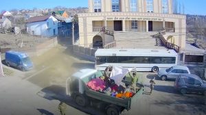 У синагоги в городе Умань украинские неонацисты в кузове самосвала маскируют оружие и боеприпасы. Рядом – школьный автобус в их распоряжении.