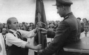 Председатель совета дружины касторенской средней школы № 1 Галя Багина принимает у фронтовиков Боевое пионерское знамя. 11 августа 1945 г.