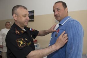 Представитель Главного организационно-мобилизационного управления Генерального штаба Вооружённых Сил Российской Федерации награждает орденом Мужества начальника штаба добровольческого отряда Николая ЕФРЕМОВА.