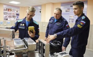 Подполковник Андрей БУРАКОВ с участниками военно-научной секции факультета инженерно-аэродромного обеспечения ВУНЦ ВВС «Военно-воздушная академия имени профессора Н.Е. Жуковского и Ю.А. Гагарина»  у тестируемой электромагнитной установки.